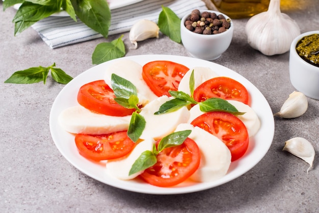 Close-up photo of caprese salad with ripe tomatoes, basil, buffalo mozzarella cheese.