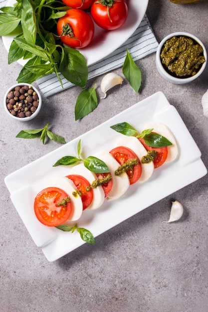 Close-up photo of caprese salad with ripe tomatoes, basil, buffalo mozzarella cheese.