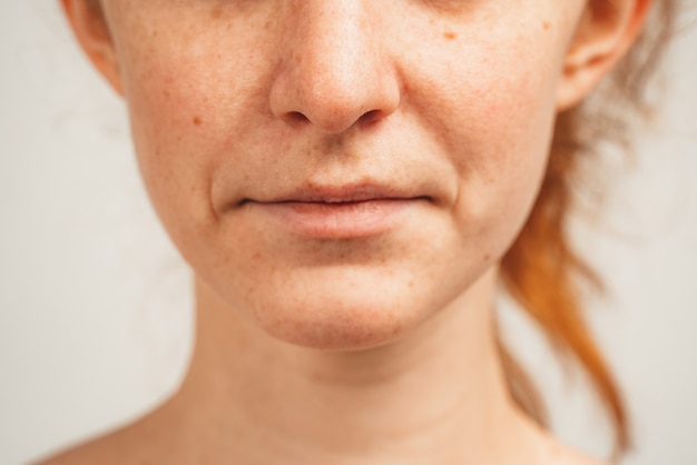 Close up photo of lower face of redhead young woman. Isolated over white background. Natural beauty and health.