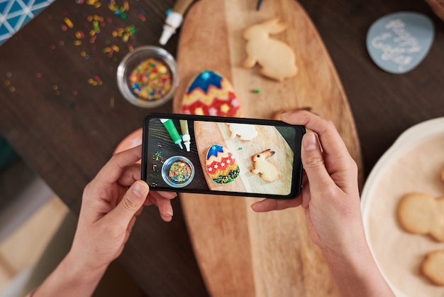 Close-up of photo on mobile phone of gingerbread cookies prepared for Easter