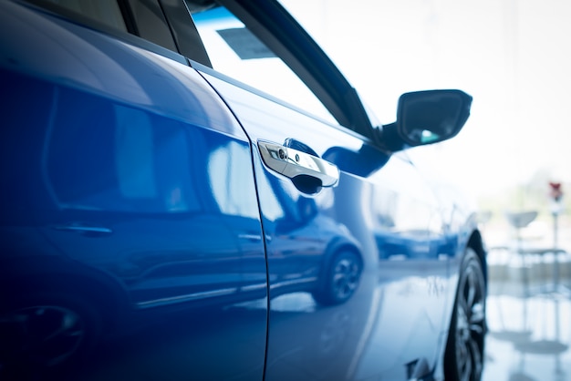 Close up photo of New blue car door. Concept for car rental.,New cars available for sale, parked in the showroom.