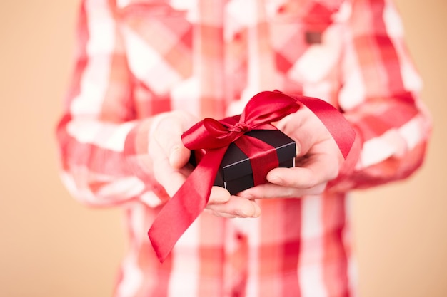 Photo close up photo of present box in male hands man holding gift box valentines day birthday or holidays concept copy space