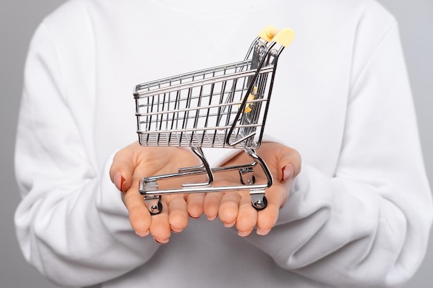 Close up photo of woman holding empty shopping trolley