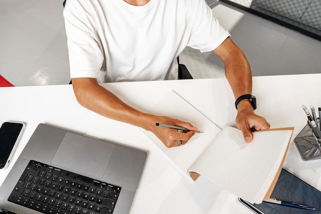 Close up photo of young businessman working at his table in office