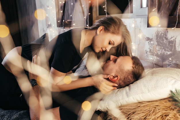 Photo close up photo of a young couple in an embrace on the bed during new years emotions passion youth hugs and kisses for christmas young couple romantic new year time