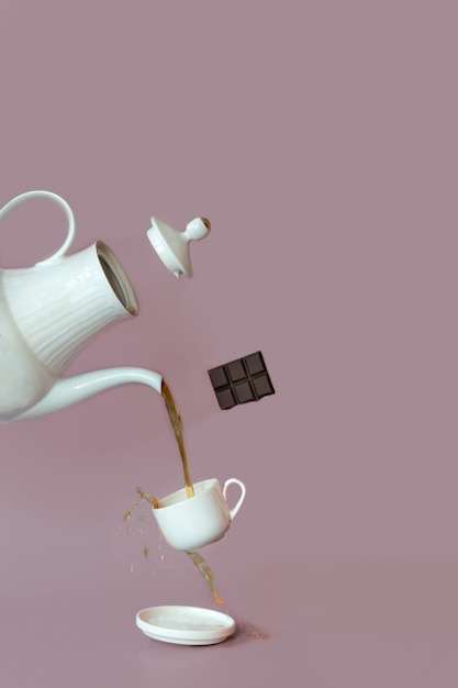 A close up photography of a tea using a teapot and cup. Coffee and tea, chocolate, food levitation.