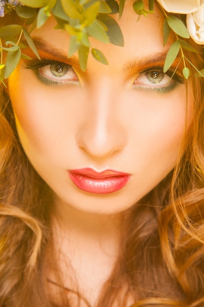 Close up picture of attractive woman with flowers in studio