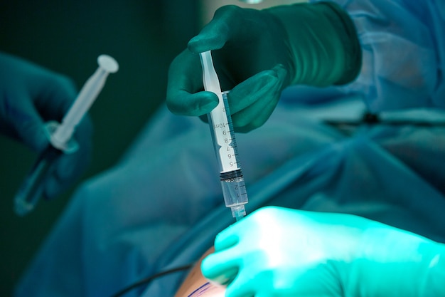 Close up picture of doctor 's hand while inject the anesthetic agent under the patient 's skin. Local anesthesia was use before perform surgery