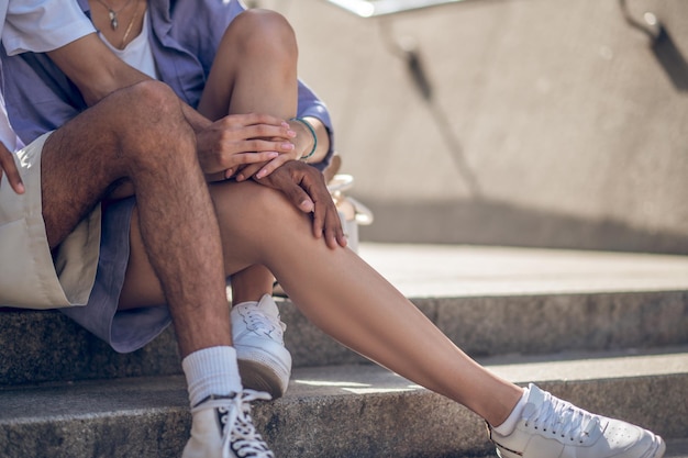 Close up picture of two people sitting close and holding hands