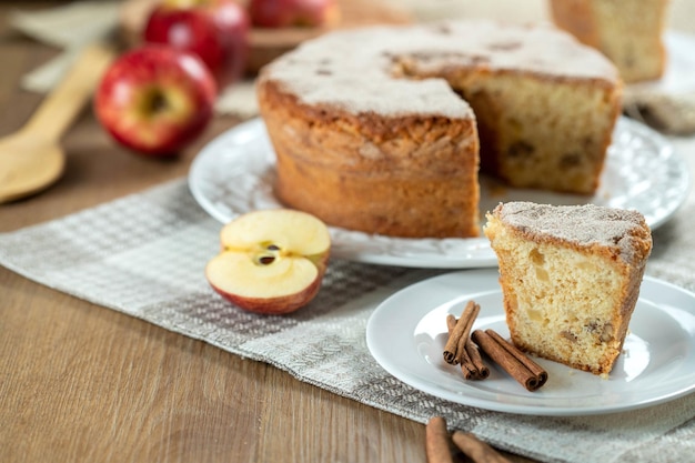 Close up piece of Sponge cake or chiffon cake with apples so soft and delicious sliced with ingredients cinnamon eggs flour apples on wooden table Home bakery concept for background and wallpaper