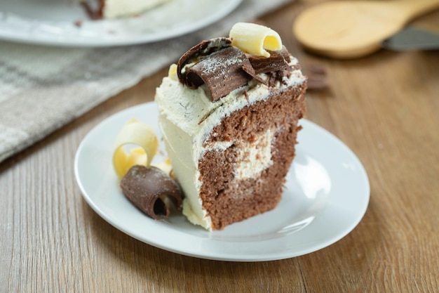 Close up piece of White chocolate and dark chocolate cake two loves on wooden table Birthday and wedding cake