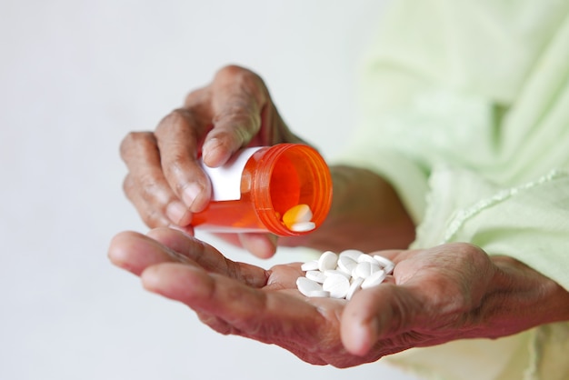 Close up of pills and capsule on senior womens hand