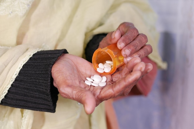 Close up of pills and capsule on senior womens hand