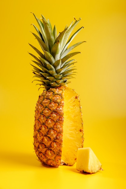 close-up of pineapple on a yellow background with pice of pineapple