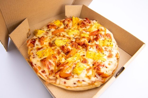 Close up of a Pizza in a cardboard box against on white background
Pizza delivery. Pizza menu.