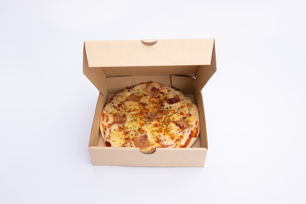 Close up of a Pizza in a cardboard box against on white background
Pizza delivery. Pizza menu.