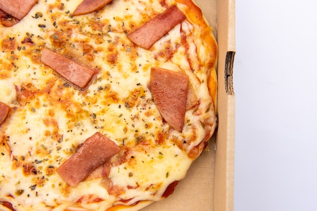 Close up of a Pizza in a cardboard box against on white background
Pizza delivery. Pizza menu.