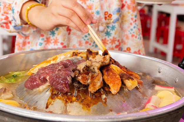 Close up of pook bbq Thai food style shabu sukiyaki or MooKaTa griiled pork