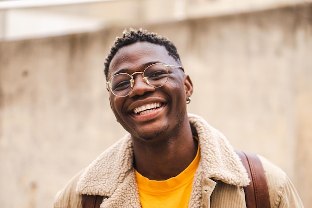 Close up portrait of african american teenage boy looking at camera smiling laughing at univesity