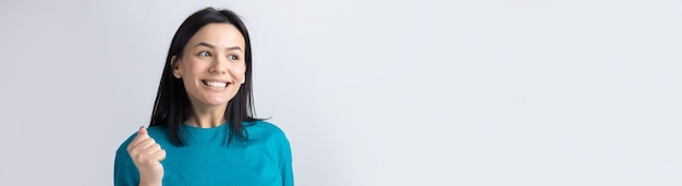 Close up portrait of attractive shouting in winning smiling with raised fists young she her girl wearing jeans shirt clothes isolated on grey background