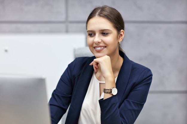 Close up portrait of attractive smiling businesswoman at workplace