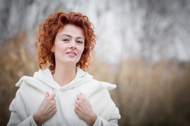 Close up portrait of attractive woman in trendy white coat