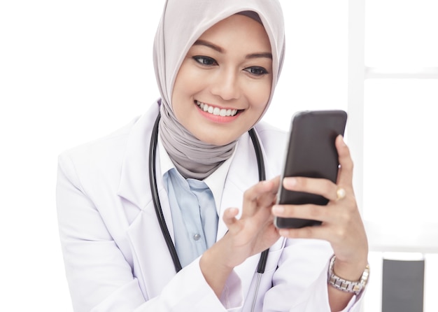 Close up portrait of beautiful asian female doctor using mobile phone