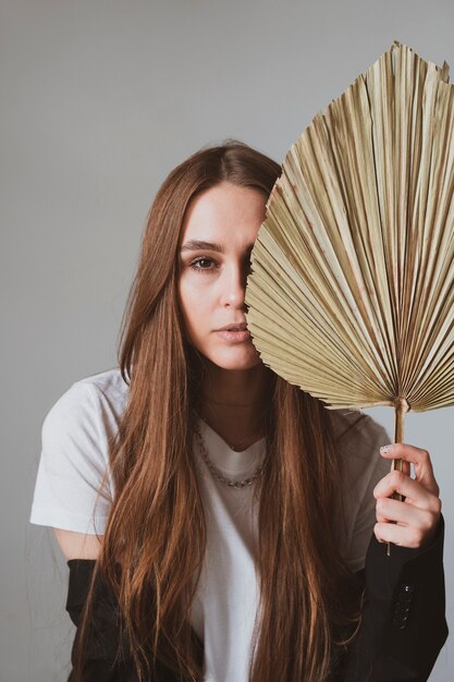 Photo close- up portrait of beautiful brunette girl with dried flowers in a beautiful scandi room