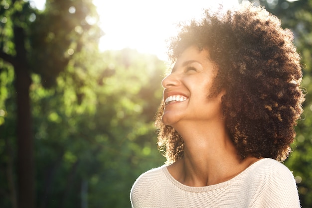 Close up portrait of beautiful confident woman laughing in nature