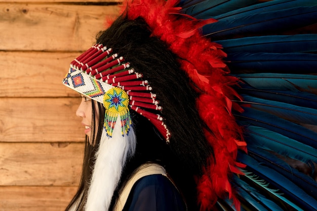 Photo close-up portrait of a beautiful girl wearing native american indian chief headdress