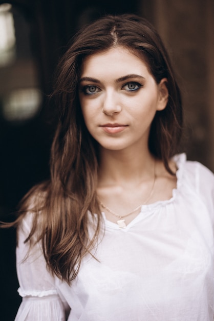 Close-up portrait of a beautiful girl in a white dress