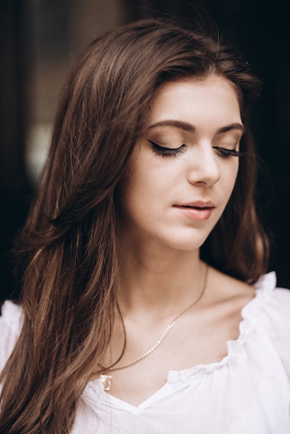 Close-up portrait of a beautiful girl in a white dress