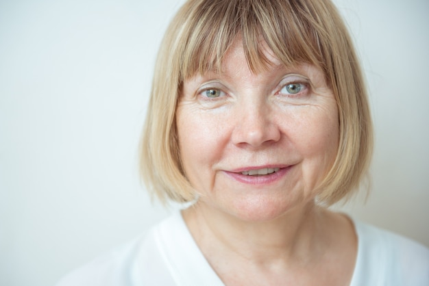 Close up portrait beautiful older woman against white background. Senior Citizen's Day. Caring for the elderly