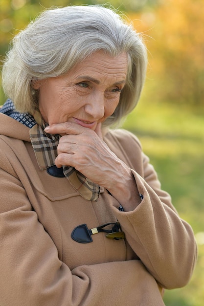 Photo close up portrait of beautiful senior woman posing in autumn park