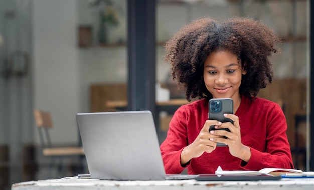 Close up portrait of beautiful young african american woman reading text message on mobile phone at coffee shop