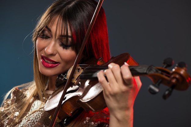 Close-up portrait of a beautiful young woman playing the violin