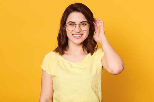 Close up portrait of beautiful young woman with dark hair and charming cute smile while posing