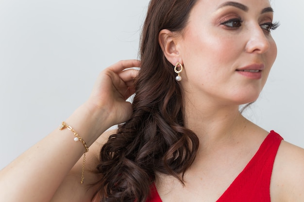 Close-up portrait of beautiful young woman with elegant luxurious jewelry and bijouterie.