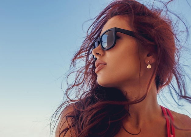 Close up portrait of brunette woman in a sunglasses.