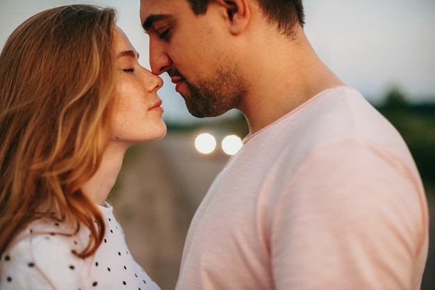 Close up portrait of a caucasian couple trying to kiss outside while dating lovers holiday love dati