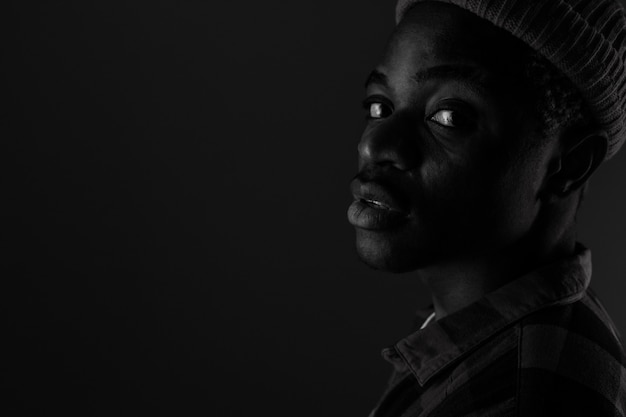 Close-up portrait of a charming handsome black guy with closed eyes in black and white light