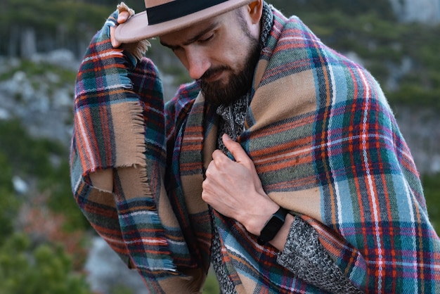 Close up portrait of confident bearded man in a mountains young hipster hiking forest