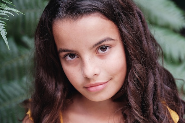 Close up portrait of a confident, charming and gorgeous mixed multicultural preteen girl with beautiful curly hair.