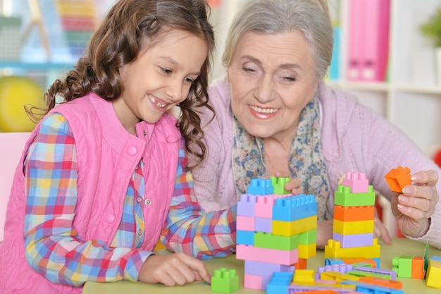 Close up portrait of cute girl and grandmother playing