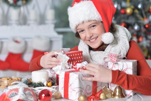 Close up portrait of girl in Santa hat with gifts