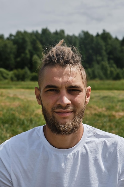 Close up portrait of handsome Caucasian bearded man with dreadlocks Athlete in white