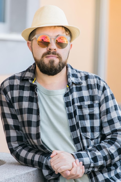 Close up portrait handsome man wearing sunglasses over urban background travel vacations and summer holiday concept