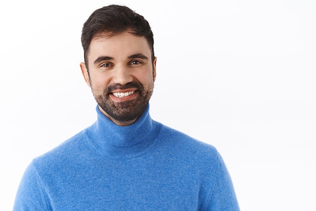 Close-up portrait of handsome successful businessman with beard, smiling happy and satisfied, express enthusiasm and positivity, staying on bright side, standing white wall joyful