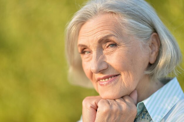 Close up portrait of happy beautiful elderly woman posing outdoors