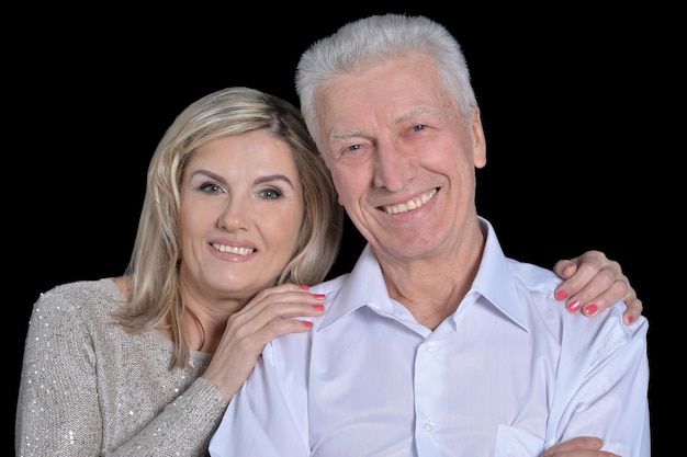 Close up portrait of happy senior couple posing on black background